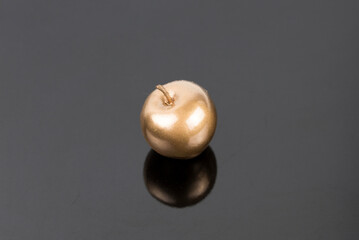 Golden apple on dark reflective background