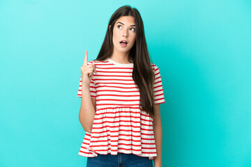 Young Brazilian woman isolated on blue background thinking an idea pointing the finger up