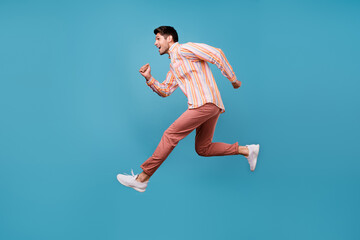 Fototapeta na wymiar Full size profile side photo of young man happy positive smile jump run hurry sale isolated over blue color background