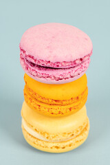 Cake macaron or macaroon on turquoise background from above, colorful almond cookies, pastel colors, vintage card