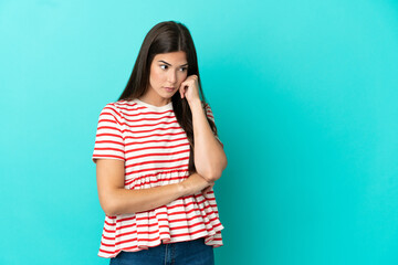Young Brazilian woman isolated on blue background with tired and bored expression