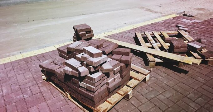 Pavement tiles concrete brick stack on a wooden pallet in the street orbiting shot