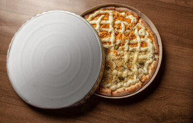 Pizza, pizza delivery inside the cardboard box used for delivery on a table, top view.