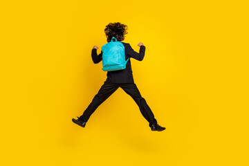 Fototapeta na wymiar Rear back view photo of sporty winner schoolboy jump wear bag black uniform isolated yellow color background