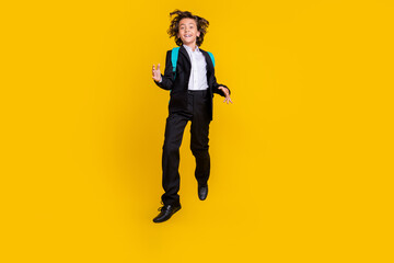 Fototapeta na wymiar Photo of funky inspired joyful schoolboy jump wear backpack black uniform isolated yellow color background