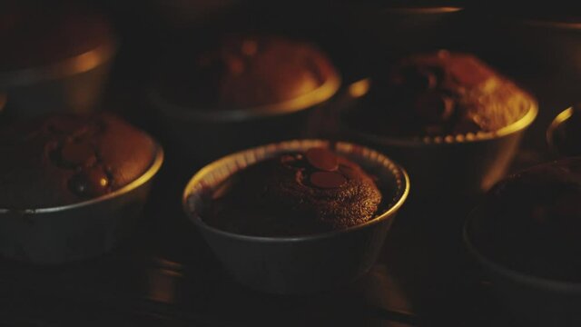 Close up and selective focus 4K of baking chocolate muffins bread placed in row in homemade oven for small bakery business looks tasty and delicious pastry dessert, and shows cooking manufacturing.