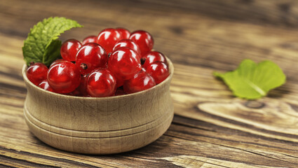 Red currants on the table in a wooden bowl