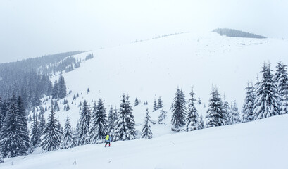 Obraz premium a man walks through the snow and cold on the mountain