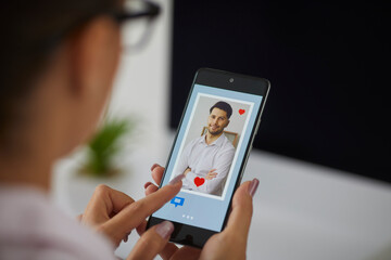 Love, finger of woman pushing heart icon on screen in mobile smartphone application. Online dating app, valentine's day concept.