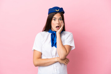 Airplane stewardess Brazilian woman isolated on pink background surprised and shocked while looking right