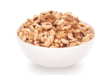Close-up of dry organic puffed wheat  in a white ceramic bowl over white background.