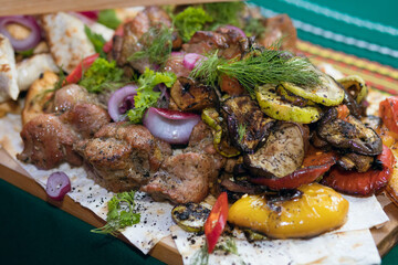 grilled meat cooked with grilled vegetables and laid out on a board. Restaurant dish ready to eat. Perfectly fried pork with vegetables