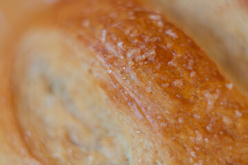 Close-up of bread. Freshly baked sourdough bread with a golden crust on bakery shelves. Bakery context with delicious bread. Confectionery.