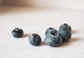 Blueberries on white background. Fresh ripe berries. Blueberry close up. Vitamin and antioxidant concept. Organic food. Healthy nutrition. Sweet berries on wooden table. Summer fruits. Raw dessert.