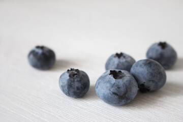 Blueberries on white background. Fresh ripe berries. Blueberry close up. Vitamin and antioxidant concept. Organic food. Healthy nutrition. Sweet berries on wooden table. Summer fruits. Raw dessert.