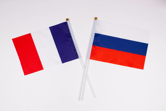 Flag of France and flag of Russia crossed with each other on a white background. Isolated. The image illustrates the relationship between countries. Photo for news and articles on the media