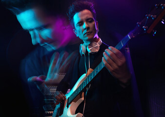 Handsome male musician with electric guitar in recording studio. Guitarist performance. Guitar player strumming. Rock music concept. Multiple exposure neon atmosphere on background.