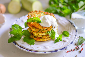 Zucchini fritters, vegetarian zucchini pancakes, served with fresh herbs and sour cream