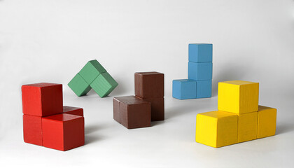 Obraz premium Multi-colored cubes of various geometric shapes for the development of spatial and logical thinking in young children. Three-dimensional shapes. Isolated objects..
