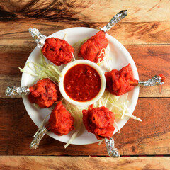 Chicken lollipop is Indian starter, served over a wooden rustic background. selective focus