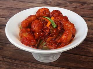 Veg Crispy is Batter Fried vegetables tossed with Chinese sauce tastes tangy. It's a popular Starters or appetizer in India. served over a rustic wooden table. selective focus
