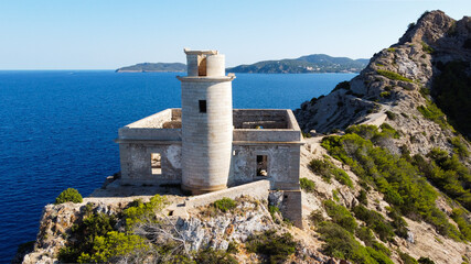 Fototapeta na wymiar Aerial view of the abandonned lighthouse on the Punta Grossa cape, in the east of Ibiza island in the Balearic Islands, Spain - Ruins of a square based lighthouse with a round tower