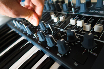 Synthesiser and hand fingers turning knobs