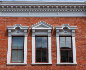 details of three arched windows in classic style on a brick wall of the house