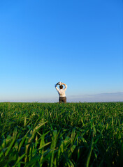 businessman poses with soccer ball in a green grass field - freelance, sport and business concept
