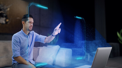 Mockup: A man works on a futuristic holographic display from home using his fingers as he touches...