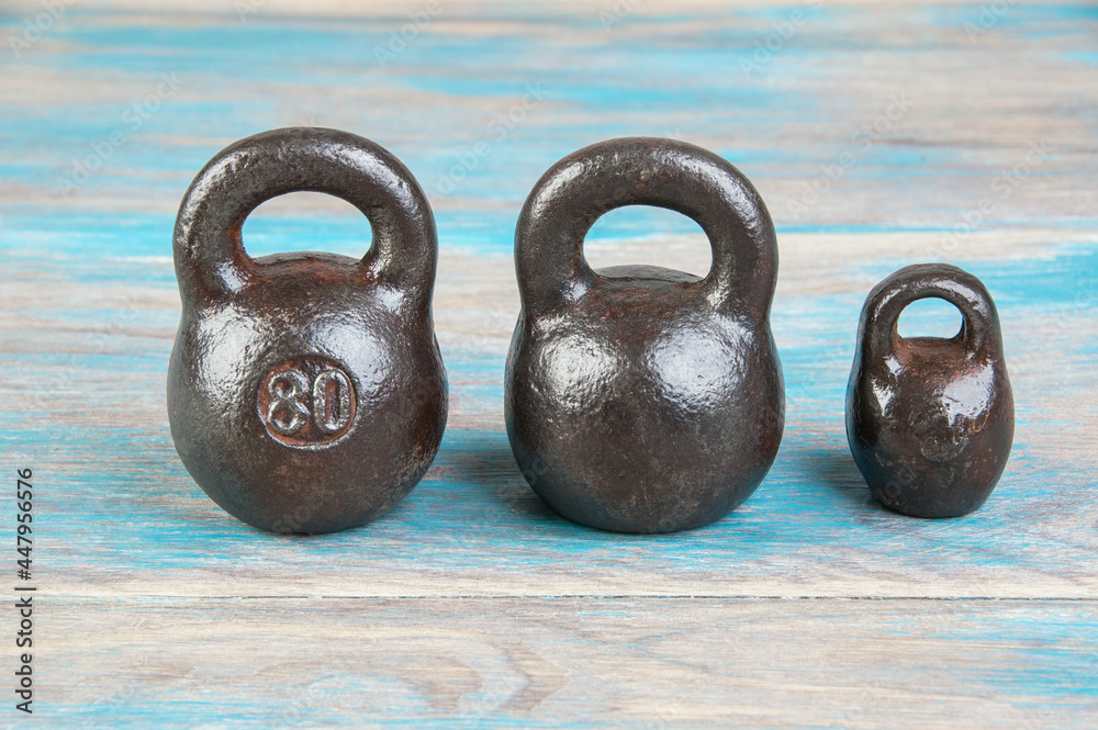 Wall mural Three antique iron weights for scales.