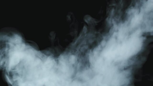Close up slowmo of smoke flowing and swirling before camera against black background