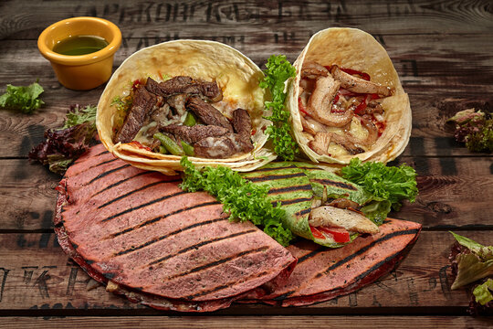 Tacos, Burrito And Quesadillas With Green Sauce And Lettuce