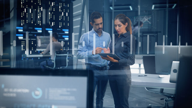Professional Male and Female Engineers Working in High Tech Research Lab with Data Servers using Computers and Tablets showing Data and Graphs. - Powered by Adobe