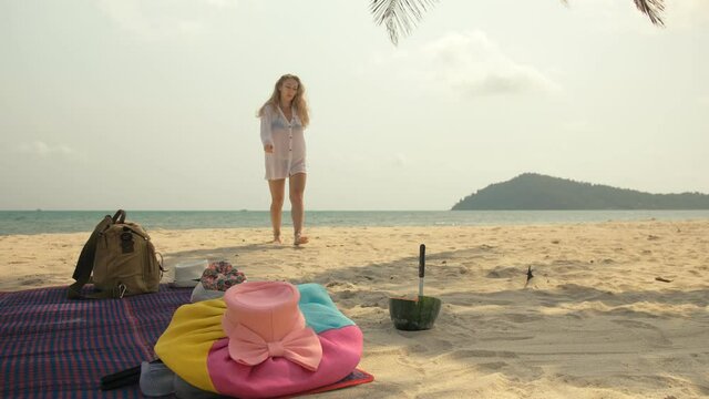 The cheerful woman holding and eating slices of watermelon on tropical sand beach sea. Portrait attractive beautiful girl caucasian spend summer weekend in outdoor. White shirt beachwear.