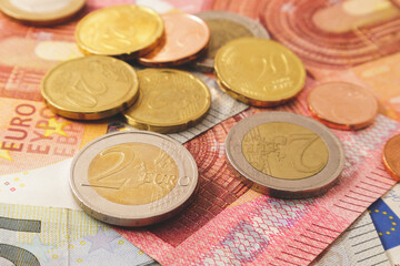 Close - up of euro coins on banknotes. Money background with soft focus