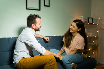 Cheerful couple joking and relaxing on the couch