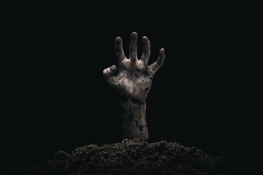 Halloween concept, zombie hand coming out from the grave. Atmosphere of horror.