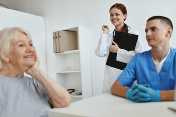 cheerful elderly woman at the reception at the hospital communicates with the nurse and the doctor