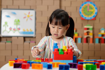 young irl playing creative toy blocks at home