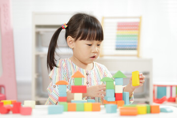  young girl playing creative toy blocks for homeschooling