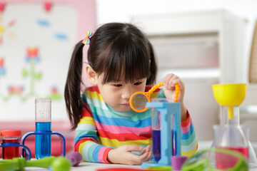 young girl playing color sorting and fine motor skill toy at home