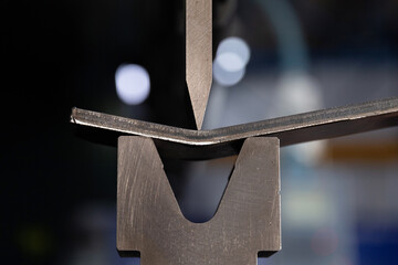 Bending sheet metal on a hydraulic machine at the factory. Bend tools, press brake punch and die....