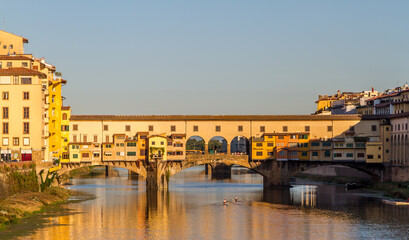 Rowers out on the River Arno during a lovely sunny morning in Florence, Italy, with the historic Ponte Vecchio in the background