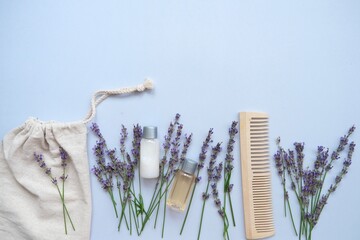 Composition with lavender and organic cosmetics In eco bag on blue background. Organic SPA beauty products for hair and body care. Flat lay, top view. Zero waste beauty products set.