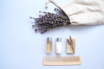Composition with lavender and organic cosmetics In eco bag on blue background. Organic SPA beauty products for hair and body care. Flat lay, top view. Zero waste beauty products set.