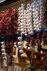 A market stall with dried garlic string and red chillies, displayed at a market stall
