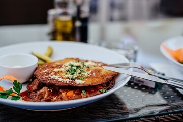 A plate with a dinner dish in a restaurant. Crispy potato pancakes and Hungarian goulash.