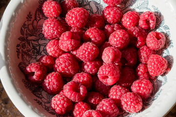 Raspberries in a plate. The collected berries of a raspberry