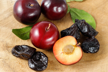 Dried plums or prunes and fresh fruits on the wooden table